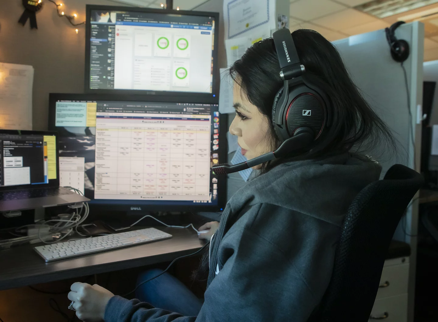 iostudio contact center representative, Brisa Morris, engaging with a customer on headphones looking at custom crm platform on computer.